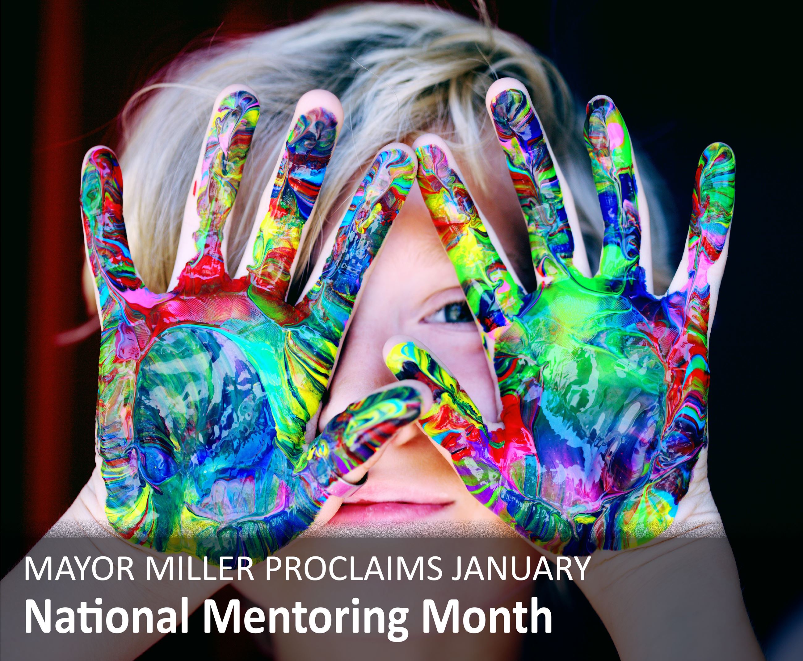 A child holding up hands with colorful paint on them