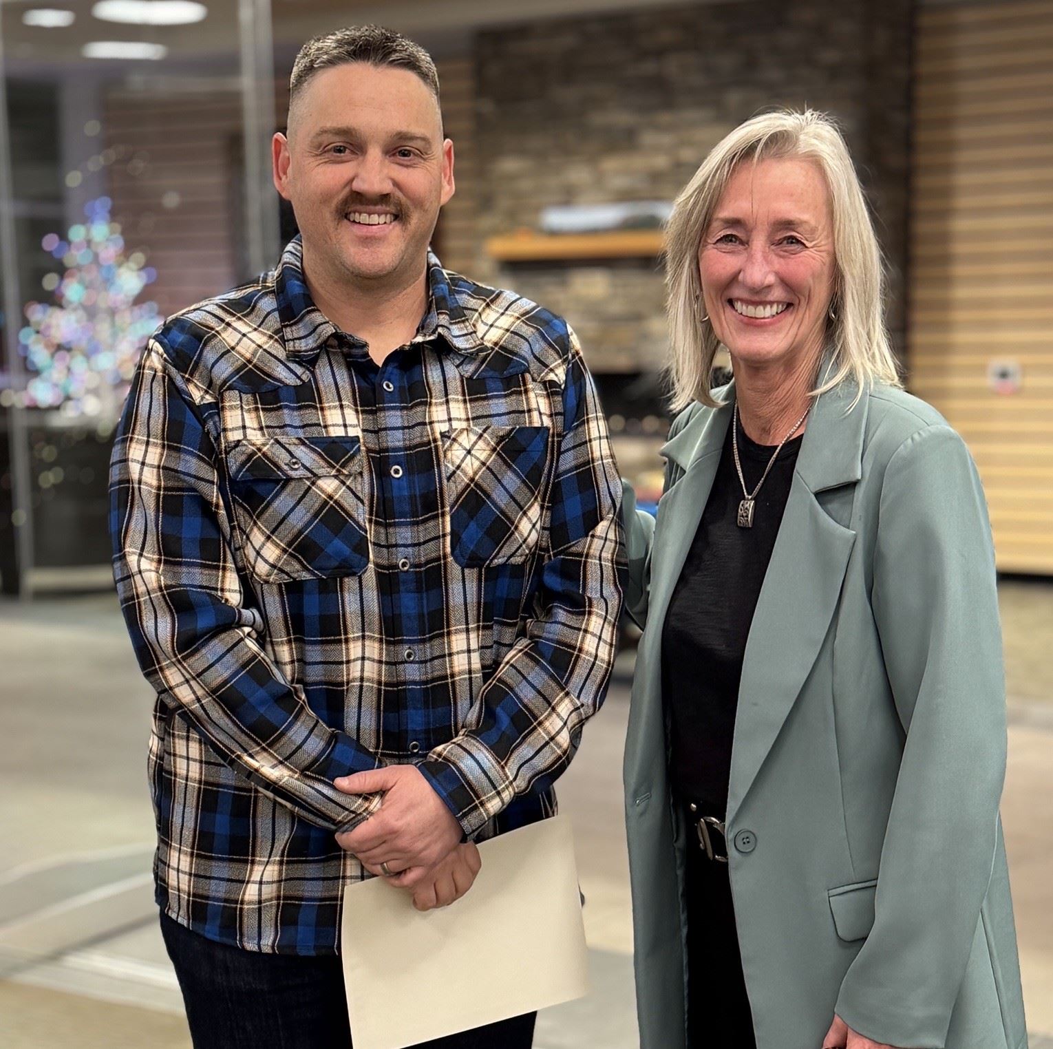 Two people smiling, holding a certificate