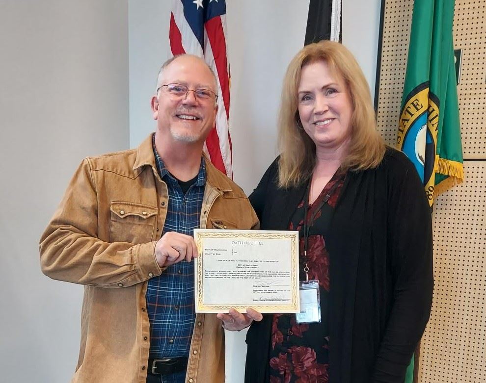 Two people smiling, holding a certificate